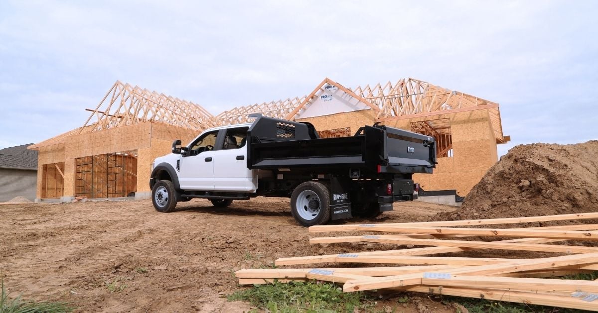 Truck with Knapheide dump body in front of house under construction