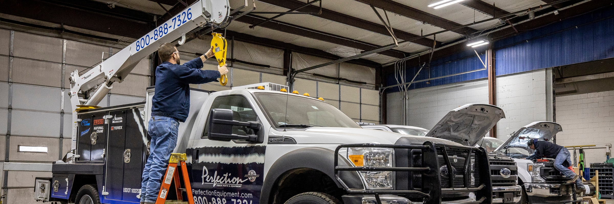 technician installing crane on truck